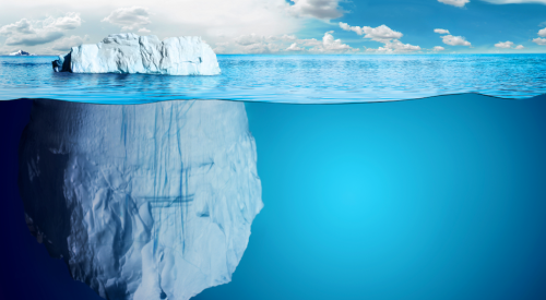 giant iceberg with bulk of the iceberg submerged under water out of view