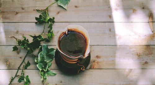 A cup of coffee and some ivy out on the deck