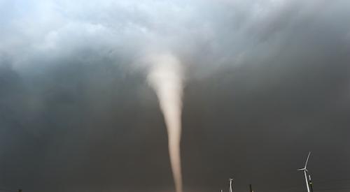 Tornado vortex in the distance moving across flat landscape 