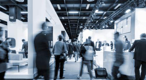 Blurred black and white image of people at construction trade show