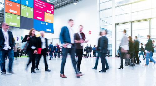 People walking through large hall at tradeshow