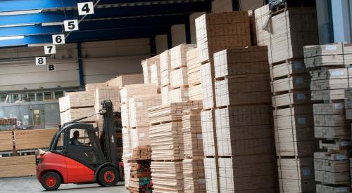 Man in warehouse transporting lumber