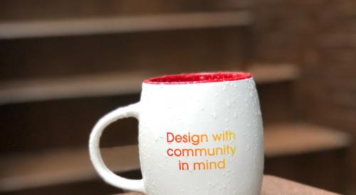 Mug that says "design with community in mind"