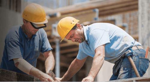 two construction workers remeasuring wall