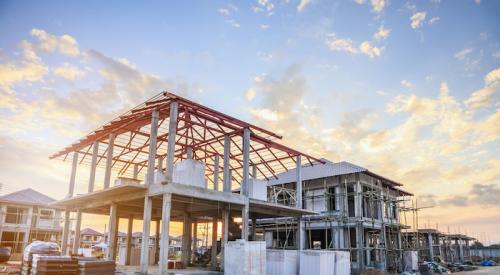 Unfinished home building site with framed home awaiting completion