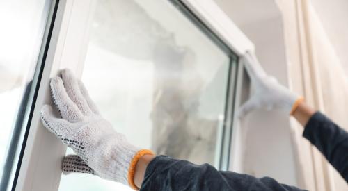 Builder installing window in house