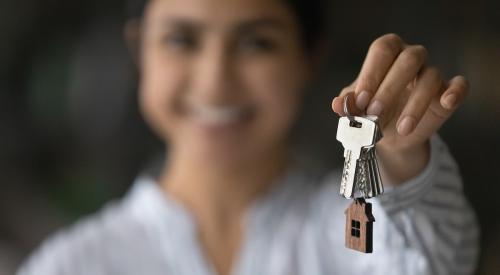 Blurred woman smiling holding silver house keys