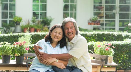 Younger boomer couple in front of home