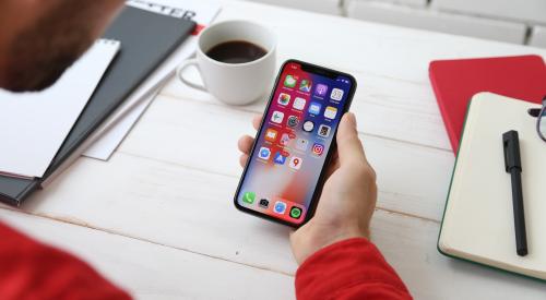 man holding smartphone and looking at app that identifies construction hazards 